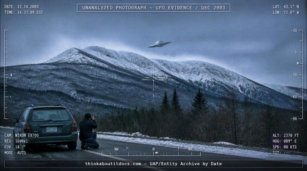 Dossier-style reconstruction of a metallic disc-shaped object against snow-covered Vermont mountains in December 2003 with wind-blown snow plumes and a photographer kneeling beside a car on the roadside below