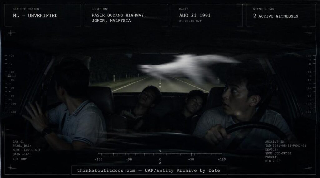 A huge silent silvery-white object crossing a car's path on a dark Malaysian highway at night, August 1991