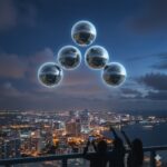 Illustration of silver spherical UAPs in formation over a coastal city during the May 2024 Florida wave.