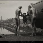 Boy lifted by two tall metallic-suited beings toward tank-like craft near Canal du Nord, Marseilles, 1921
