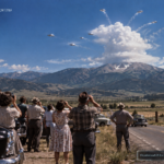 Illustration of the 1952 Ennis, Montana UFO sighting with disc-shaped objects emerging from a self-forming cloud, witnessed by a dozen people