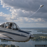 Illustration of a small plane and pilot watching a silver cone-topped disc pull up sharply toward clouds over Indian Lake, Ohio, June 25, 1954