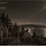 Nine people in a Tacoma yard watching a light with a silver trail shoot upward over Puget Sound, April 1951