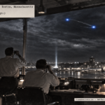 Illustration of four controllers in the Logan Airport tower watching two blue lights revolve around each other in the night sky on April 7, 1950