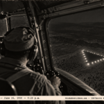1950-style photo from a C-47 cockpit of a triangular object with white lights passing below at night near Tucson