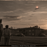 A dark oblong object with a red-white light above it climbing in steps over apartment rooftops at sunset as a man and boy watch, Warner Robins, Georgia, January 1951